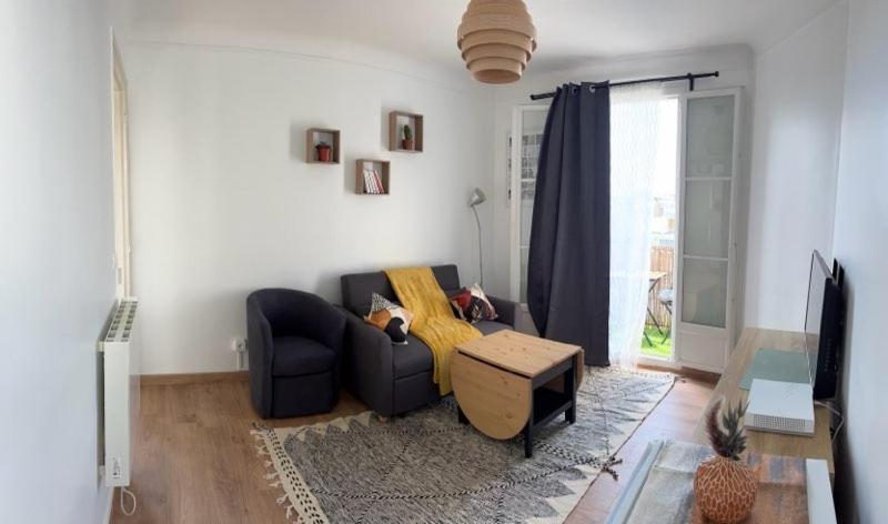 un salon avec un canapé et une télévision dans l'établissement Le petit prince, à Boulogne-Billancourt