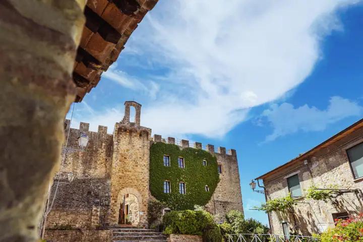 an old stone building with a green building at Castello di Cisterna in Cisterna