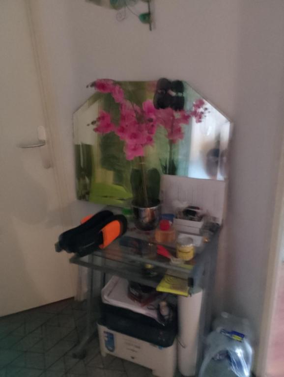 a table with a vase with a flower in it at Genicar in Lormont