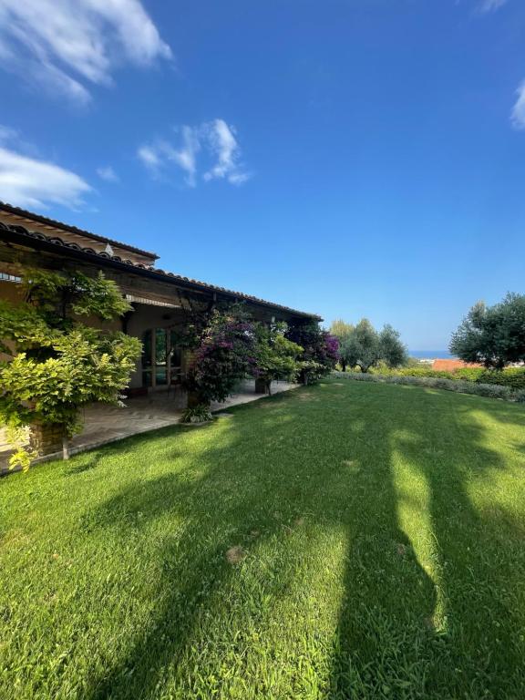 un cortile con prato verde e una casa di La BouganVillea a Francavilla al Mare