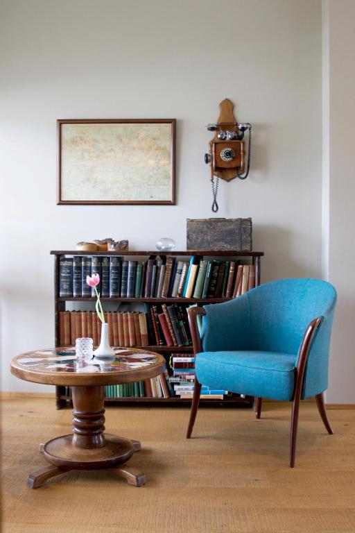 a living room with a blue chair and a table at Gistihúsið - Lake Hotel Egilsstadir in Egilsstadir