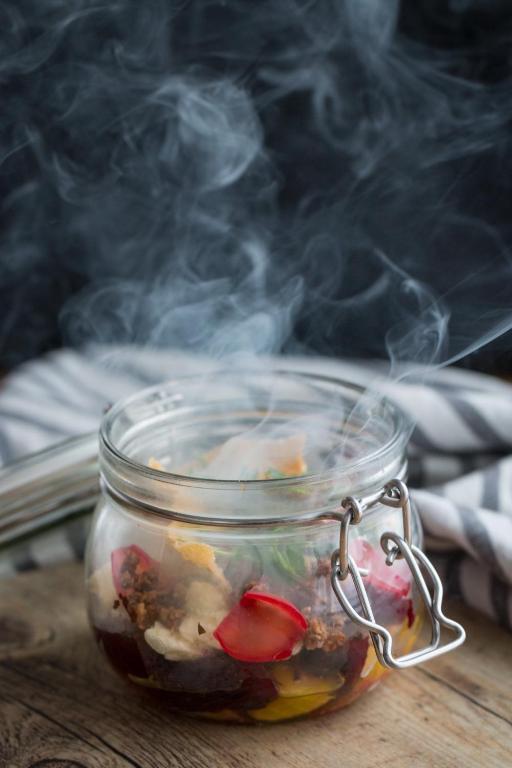 a glass jar filled with food on a table with smoke at Gistihúsið - Lake Hotel Egilsstadir in Egilsstadir