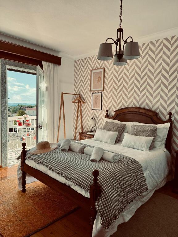a bedroom with a large bed and a window at A casa do Boubelo in Vimioso