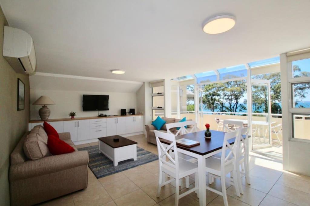 a kitchen and living room with a table and chairs at Simply THE Best Waterviews over the park in Huskisson