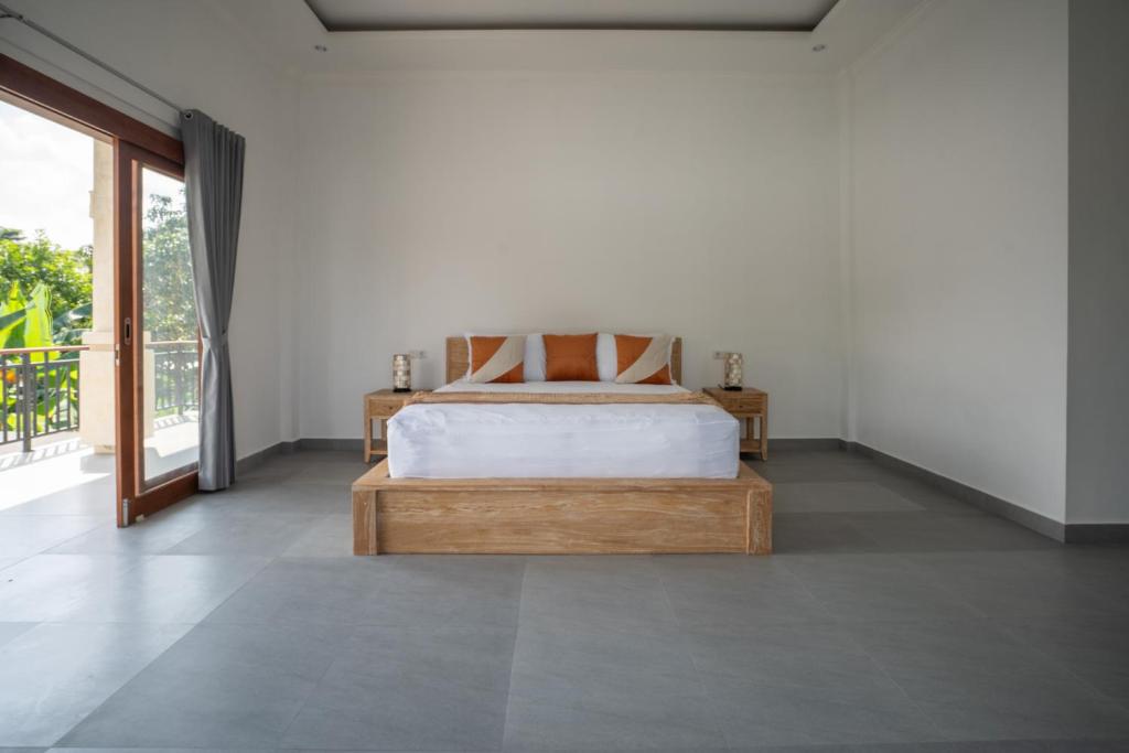 a bedroom with a bed and a large window at Beatrix Villa in Ubud