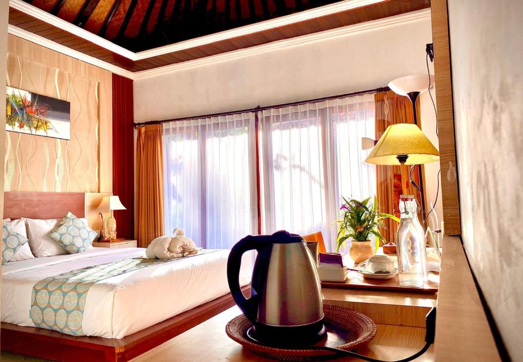 une chambre avec un lit et une table avec une bouilloire dans l'établissement Wait Garden Cottage, à Nusa Penida