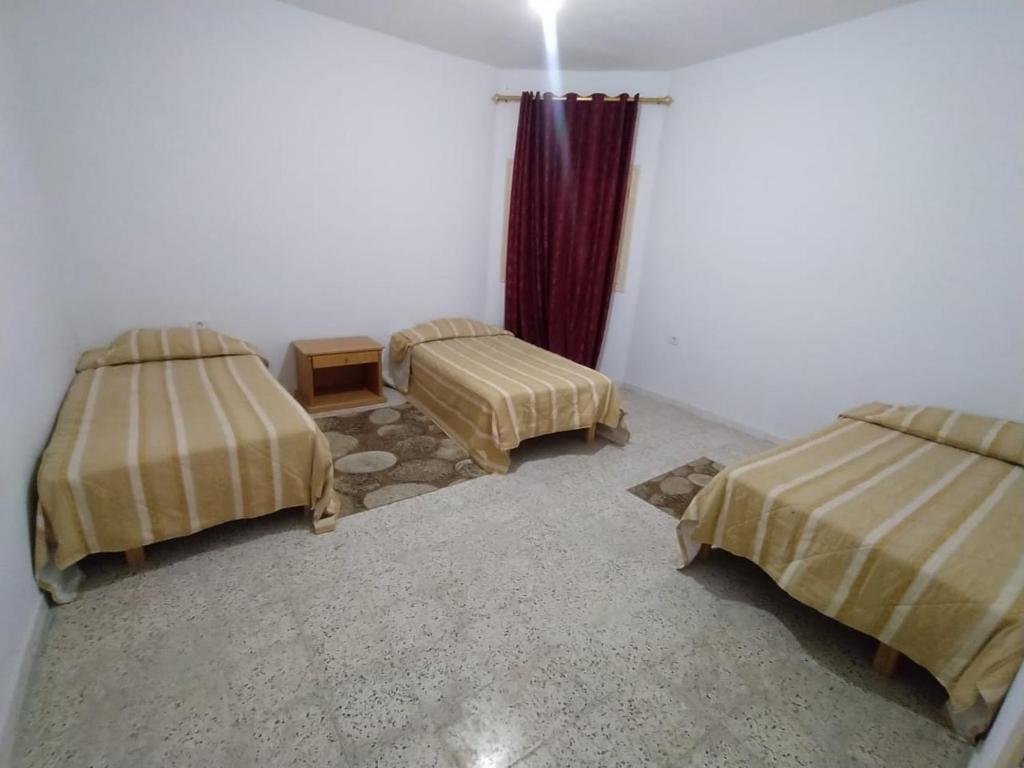 a room with two beds and a table in it at Apartments in Djerba