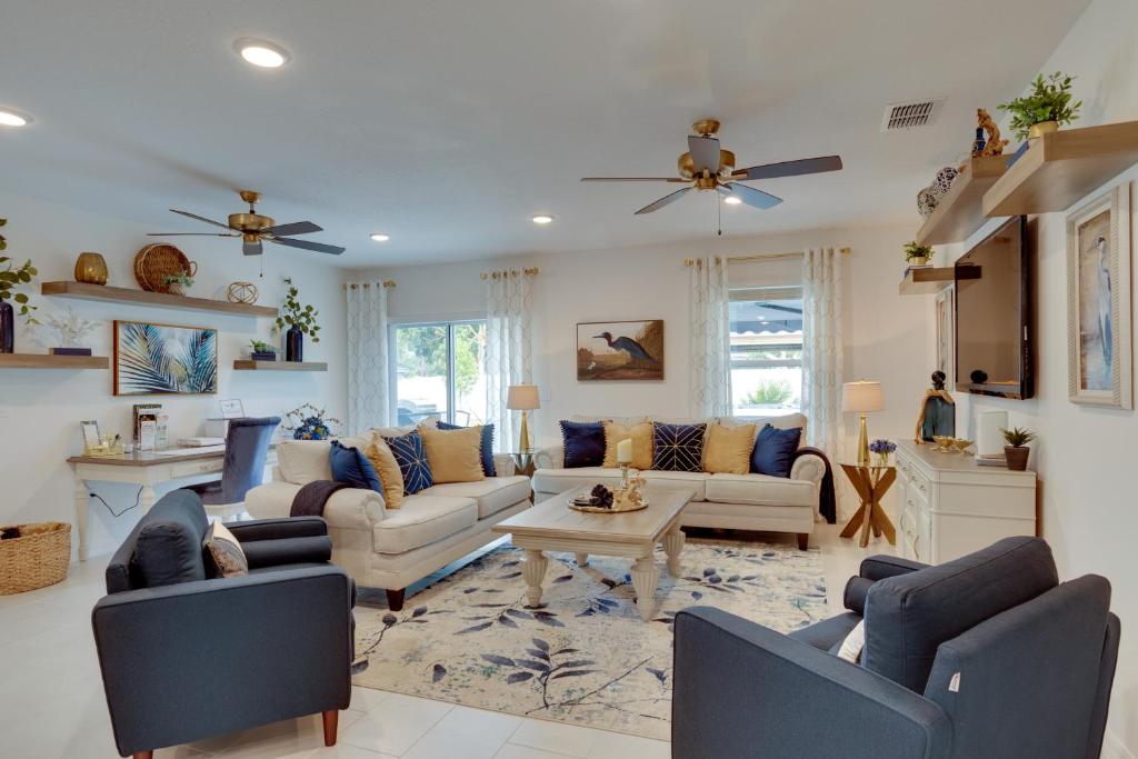 a living room with two couches and a table at Beautiful Port St Lucie Home with Hot Tub! in Port Saint Lucie