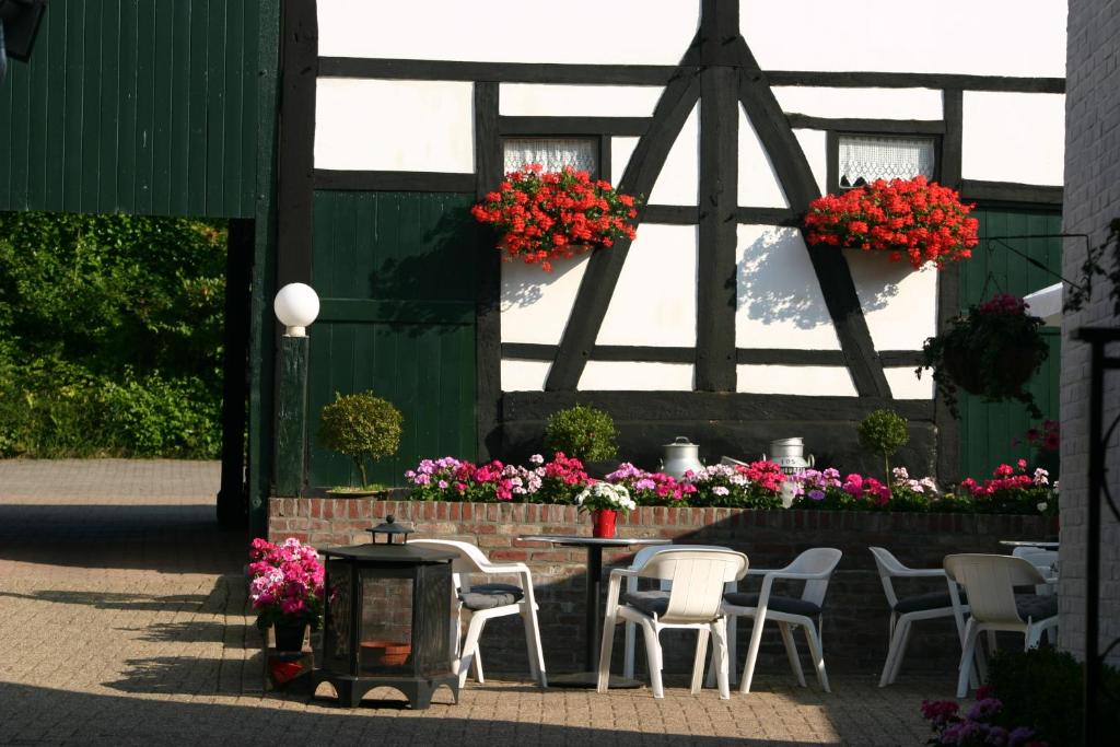 un patio con mesa, sillas y flores en 't Reijmerhöfke en Reijmerstok