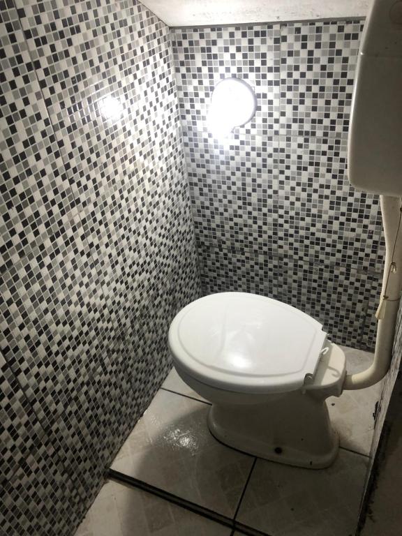a bathroom with a white toilet in a shower at Hospedagem in Barreirinhas