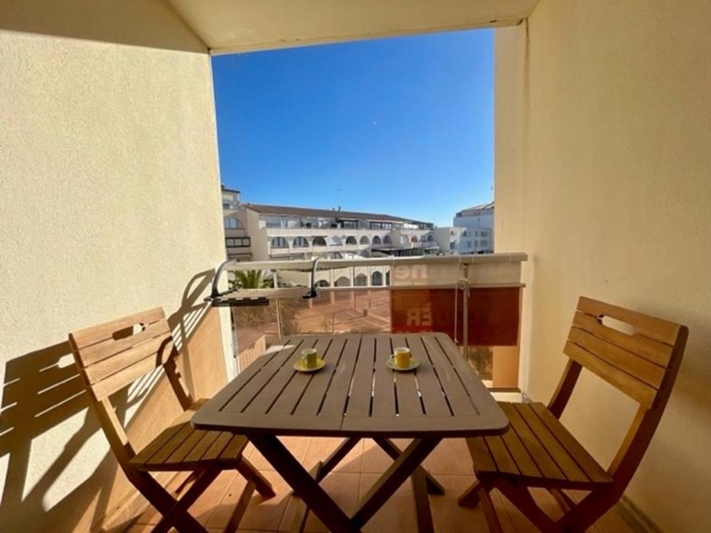 une table en bois et deux chaises sur un balcon dans l'établissement Studio près de la plage avec parking à Sète - FR-1-338-104, à Sète
