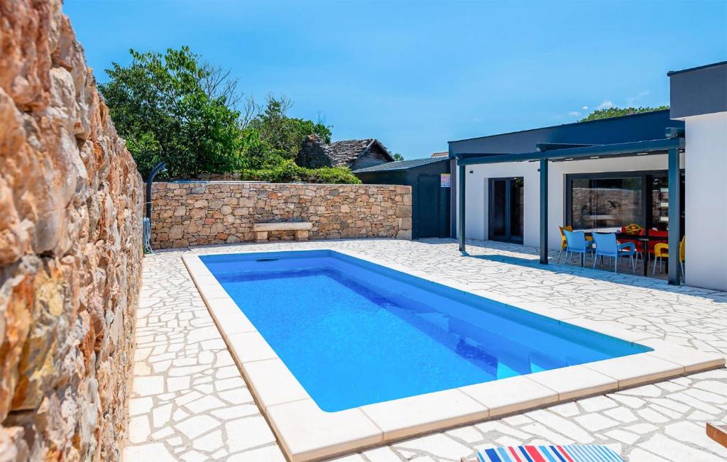 a swimming pool in a yard next to a stone wall at Nice Home In Trbounje With Wifi in Trbounje