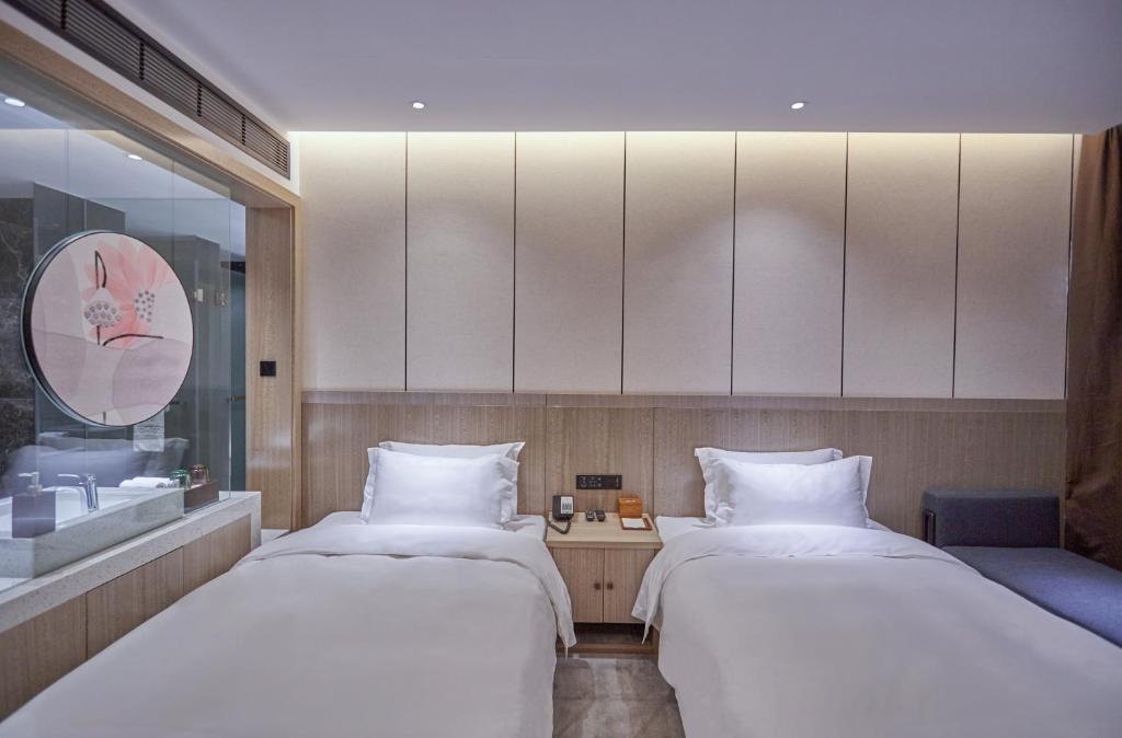 Postel nebo postele na pokoji v ubytování Paco Hotel Guangzhou Baiyun Airport Liantang Metro