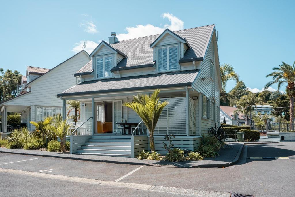 a blue house with a palm tree in front of it at Butterfly Cottage 2 or 3 Bedroom- Russell Cottages Collection in Russell