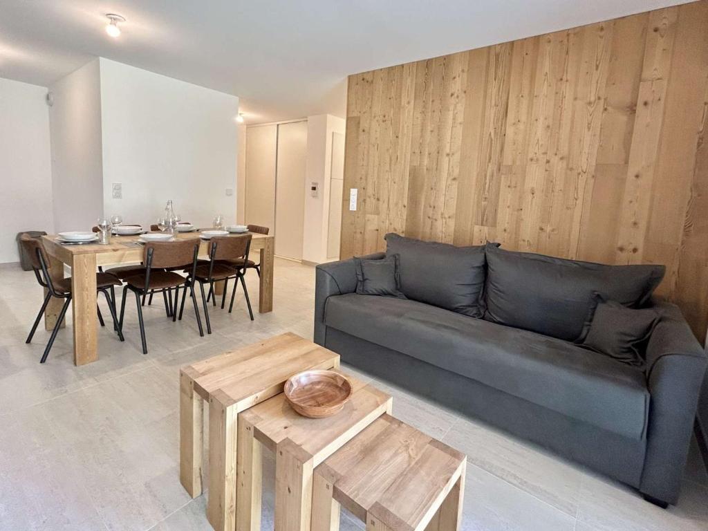 un salon avec un canapé et une table dans l'établissement Appartement Neuf 3 Pièces avec Terrasse et Jardin, Proche Remontées Mécaniques, Parking Inclus - FR-1-597-179, à Combloux