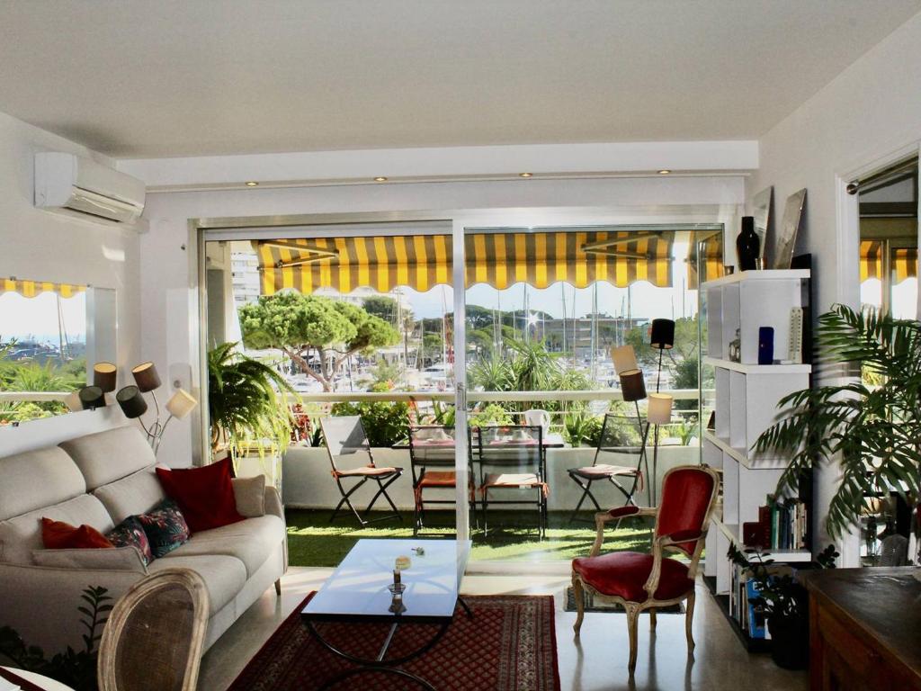 un salon avec un canapé et une table dans l'établissement Appartement pieds dans l'eau: 2 pièces, grande terrasse, climatisation, Villeneuve-Loubet - FR-1-252A-127, à Villeneuve-Loubet