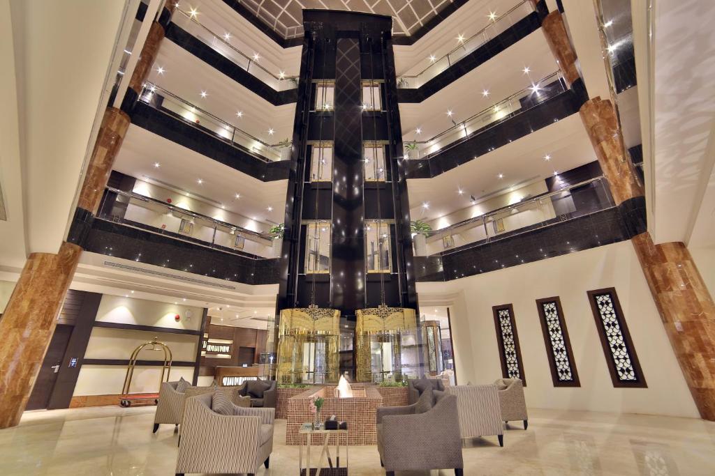 a lobby with a table and chairs in a building at Roof Hotel Apartments in Riyadh