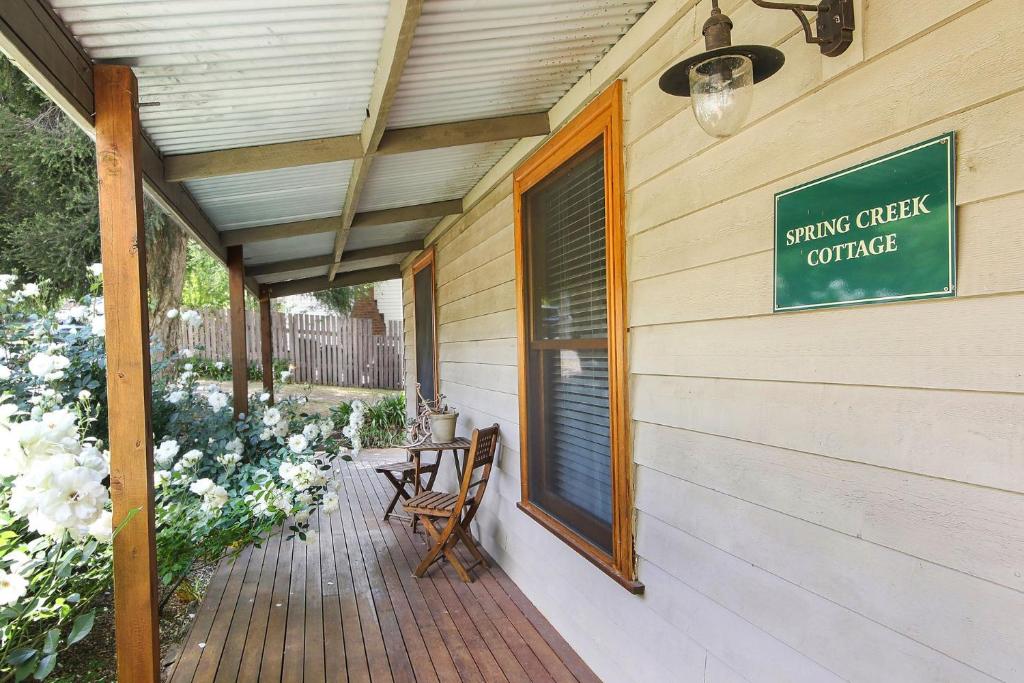 eine Veranda mit einem Schild an der Seite eines Gebäudes in der Unterkunft Spring Creek Cottage in Beechworth