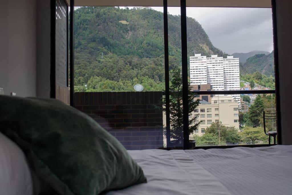 a bedroom with a bed and a large window at Apartamento en el centro Bogotá in Bogotá