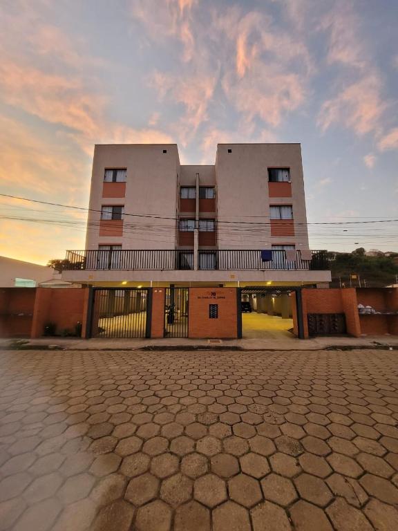 a building with a sunset in front of it at Sapucaia Flat - Apart Hotel in Santa Rita do Sapucaí