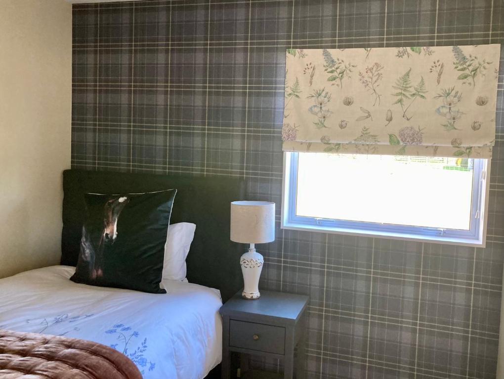 una camera con letto, finestra e lampada di Willow Tree Cottage a Lincoln