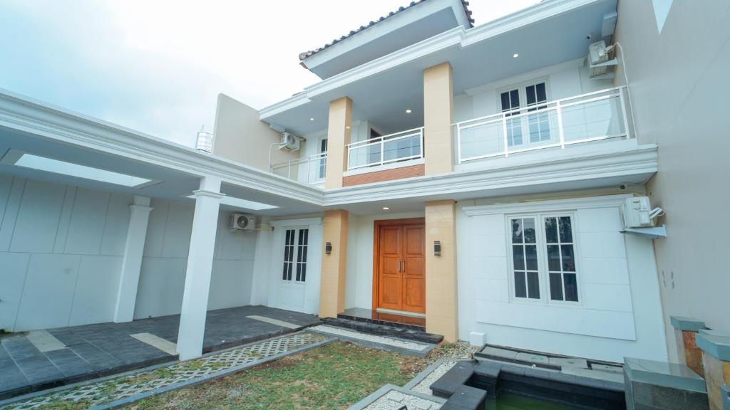 a rendering of a house with a red door at Guest House Jogja Lempongsari in Kejayan