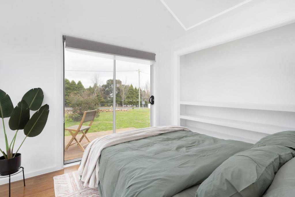 CollectorMurray Tiny Home Collector的带床和滑动玻璃门的卧室