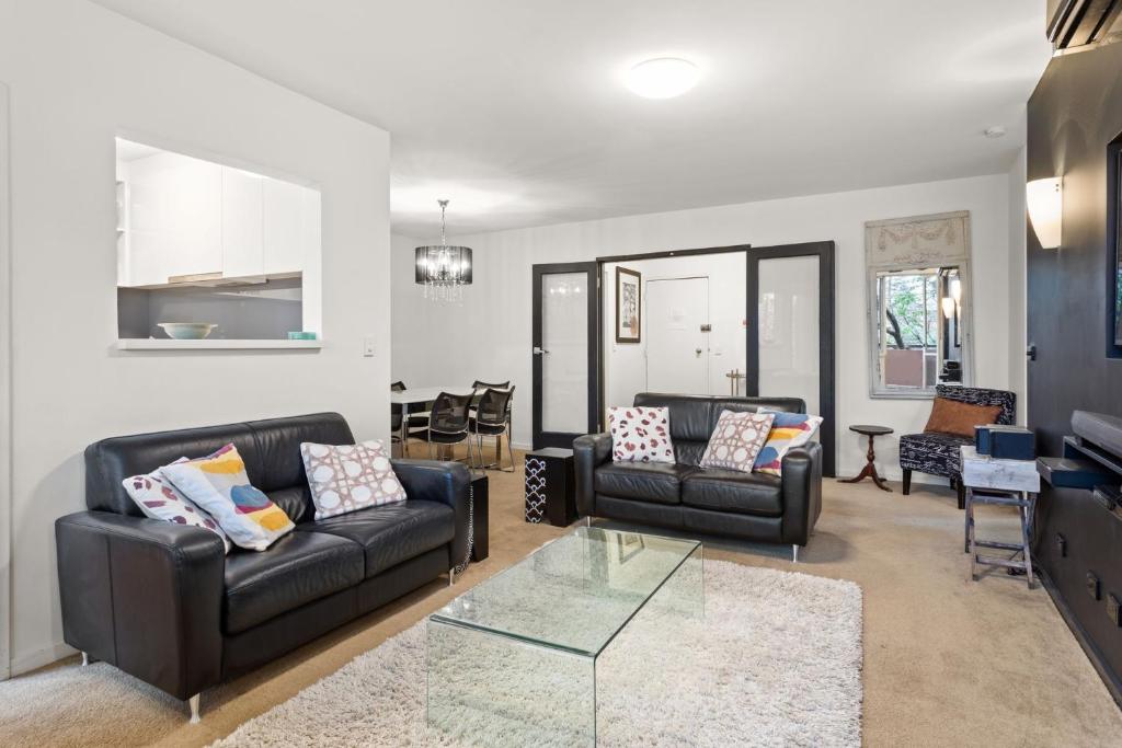a living room with two couches and a glass table at Mama Koko in Melbourne