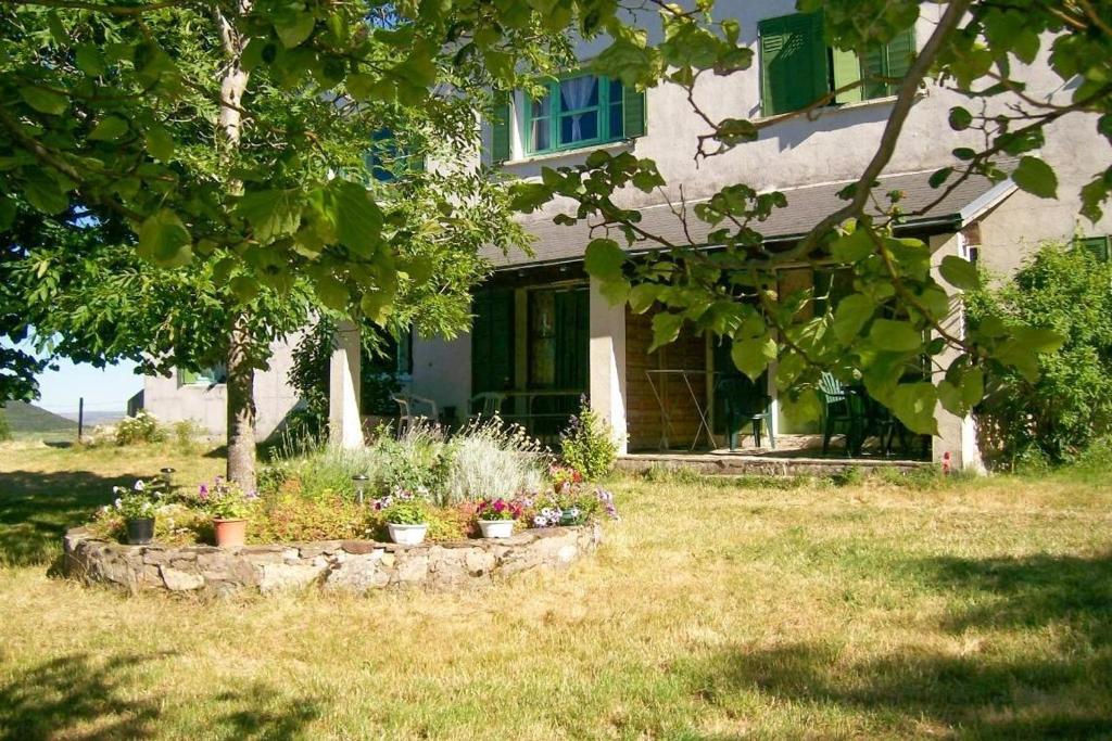 une maison avec un jardin fleuri devant elle dans l'établissement Location de vacances a masmejean, à Villeneuve