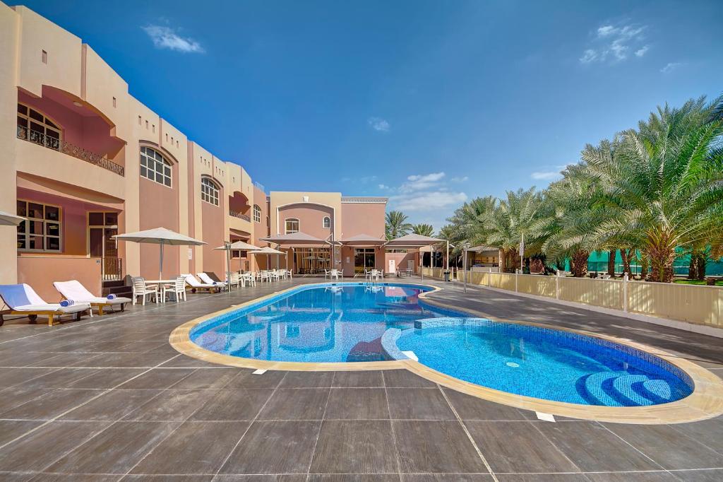 a swimming pool in the middle of a resort at Asfar Resorts Al Ain in Al Ain