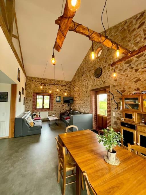 a living room with a wooden table in a room at Gîte à La Ferme de l'Oasis in Saint-Marcel-de-Félines