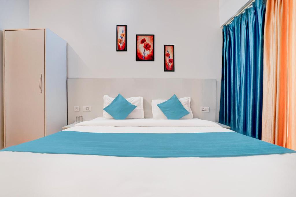 a bedroom with a large bed with blue pillows at Hotel Aradhana palace in Rishīkesh