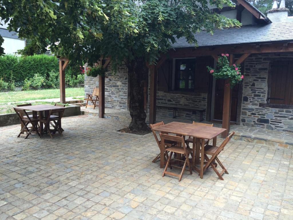 - deux tables et chaises en bois sur une terrasse en briques dans l'établissement Gîtes Au Chant des Marmites, à Saint-Lary-Soulan