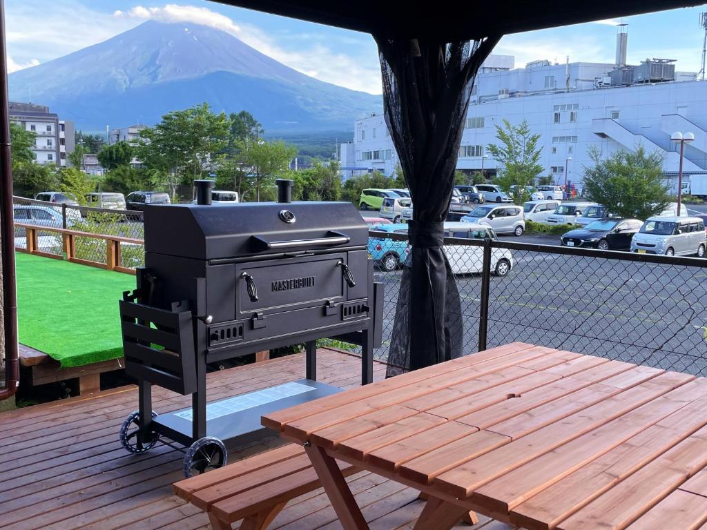 a grill on a deck with a table and a mountain at Vacation Stay Fuji - 桜館 in Fujikawaguchiko