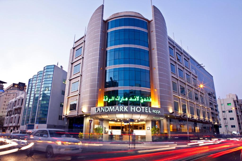 ein Gebäude auf einer Straße mit Autos davor in der Unterkunft Landmark Riqqa Hotel in Dubai