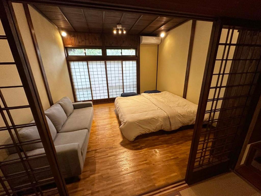 佐渡市にあるSADO-Stay02金山京町一軒家貸し切りのベッドとソファのあるリビングルーム