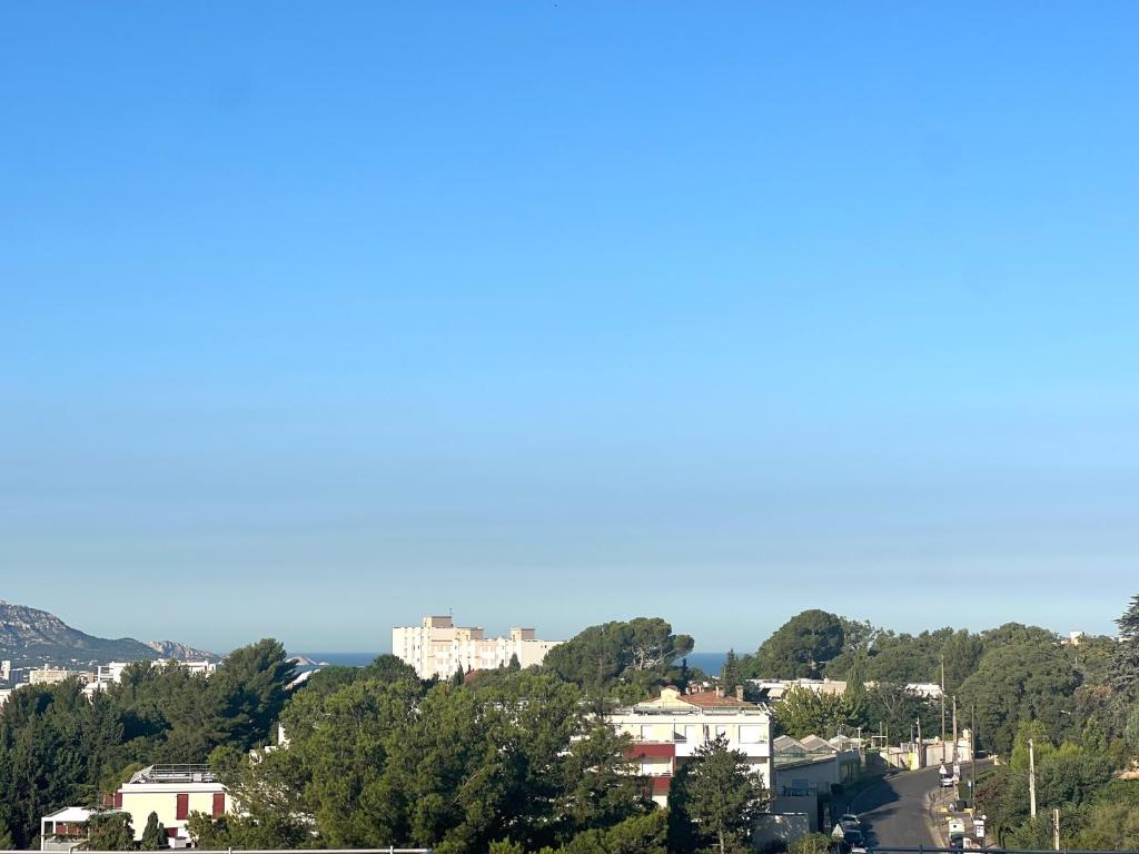 une vue d'une ville avec des arbres et des bâtiments dans l'établissement Maisons Détente Jardin, terrasse Vue Mer et Spa Marseille, à Marseille