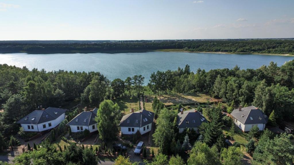 an aerial view of a house on the shore of a lake at Laguna Resort in Budzisław