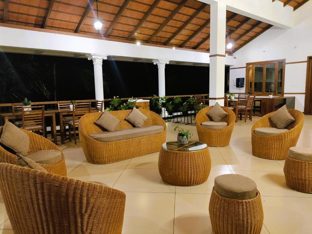 a lobby with wicker chairs and tables and a table at The Cana's Coorg in Ammatti