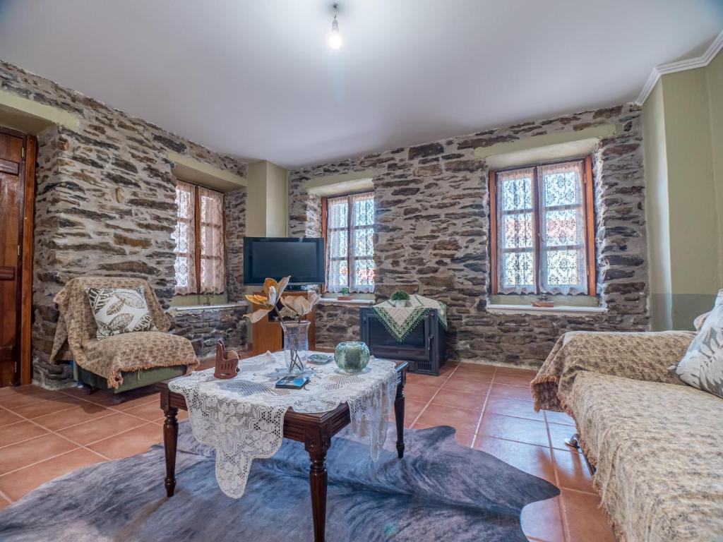 a living room with a table and a stone wall at Traditional Stone Villa 1 in Ellinikón