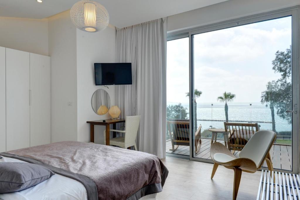 a bedroom with a bed and a view of the ocean at Residence Beach Hotel in Netanya