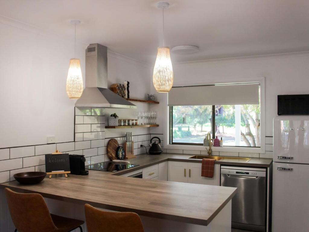 a kitchen with a wooden counter top and two lights at Buchan Motel in Buchan