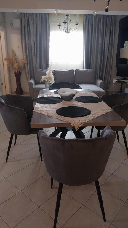 a living room with a wooden table and chairs at Ariadnis Apartment in Artemida