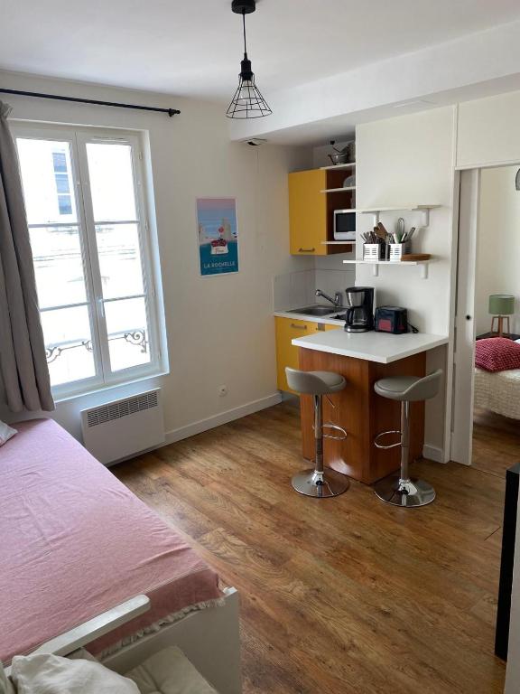 une chambre avec un lit et un bureau et une cuisine dans l'établissement Appartement 1 chambre près du Marché, à La Rochelle