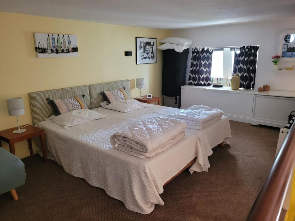 a bedroom with a bed with white sheets and pillows at Appartement vue latérale mer in Le Croisic