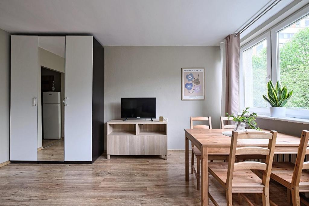 a living room with a dining room table and a television at UrbanNest - Cozy studio - Bagno 7 in Warsaw