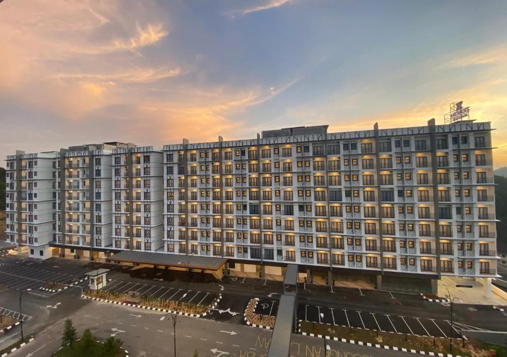 ein großes Gebäude mit einem Parkplatz davor in der Unterkunft Zenith Suites Cameron in Tanah Rata