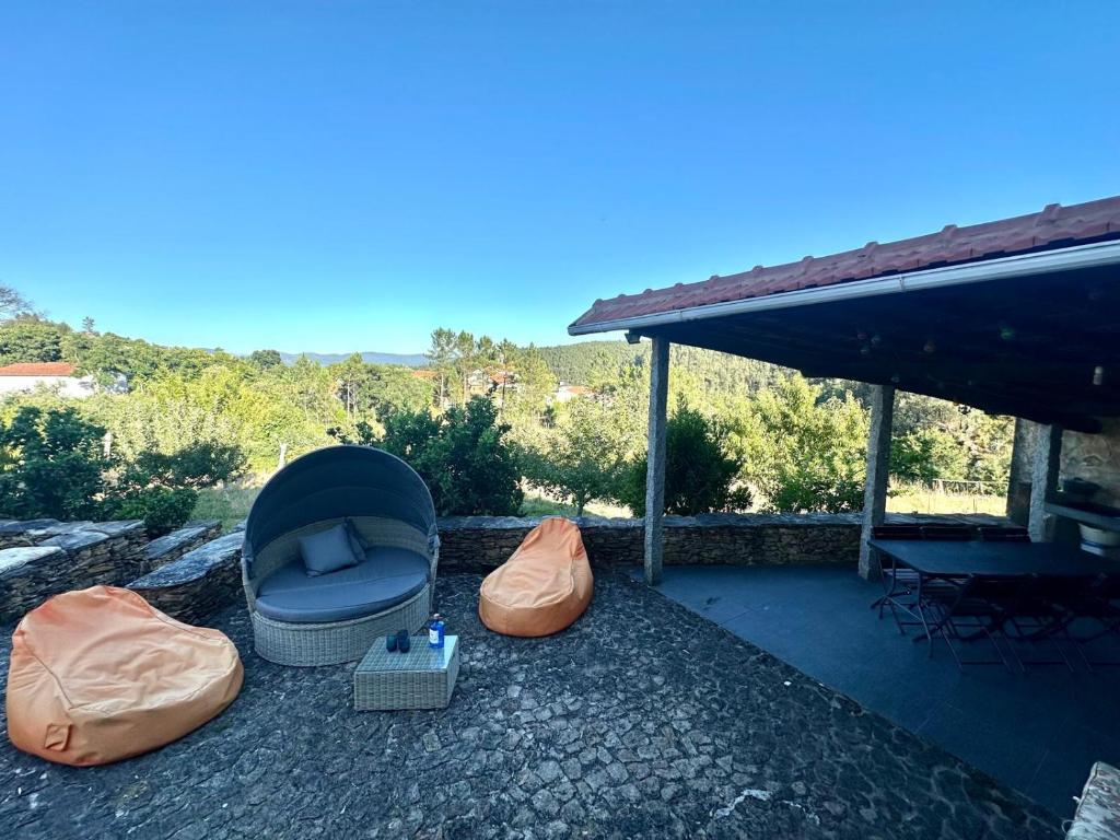 a patio with a couch and pillows on the ground at Casa da Ribeira - Arouca in Lázaro