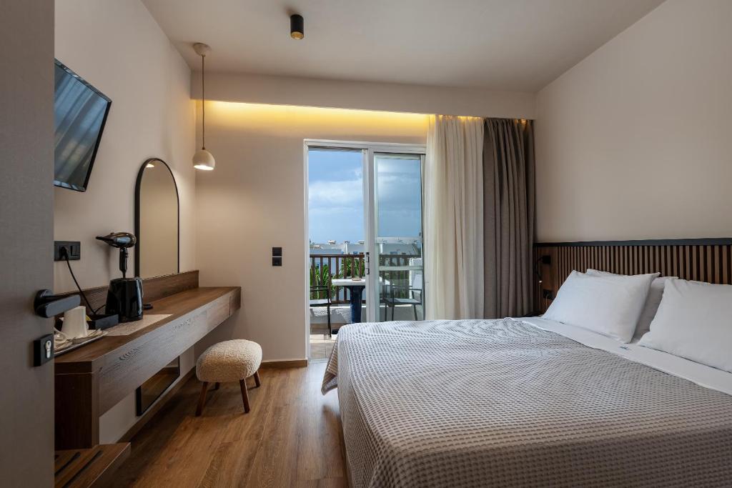 a hotel room with a bed and a window at Kalimera Mare in Kardamaina