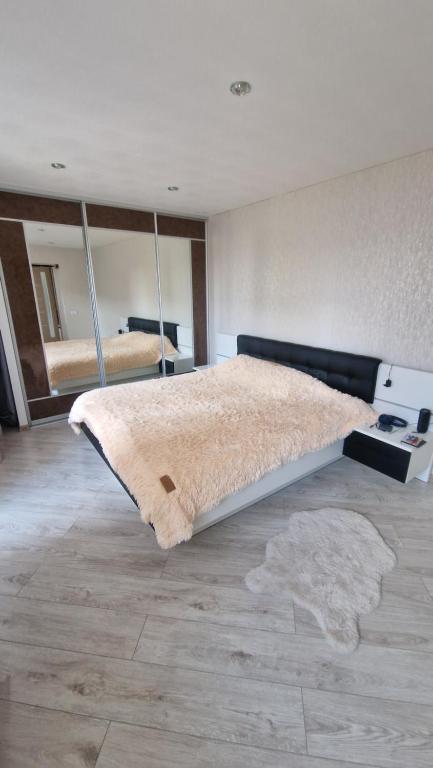 Un dormitorio con una cama grande y espejos en la pared. en MC apartments, en Rēzekne